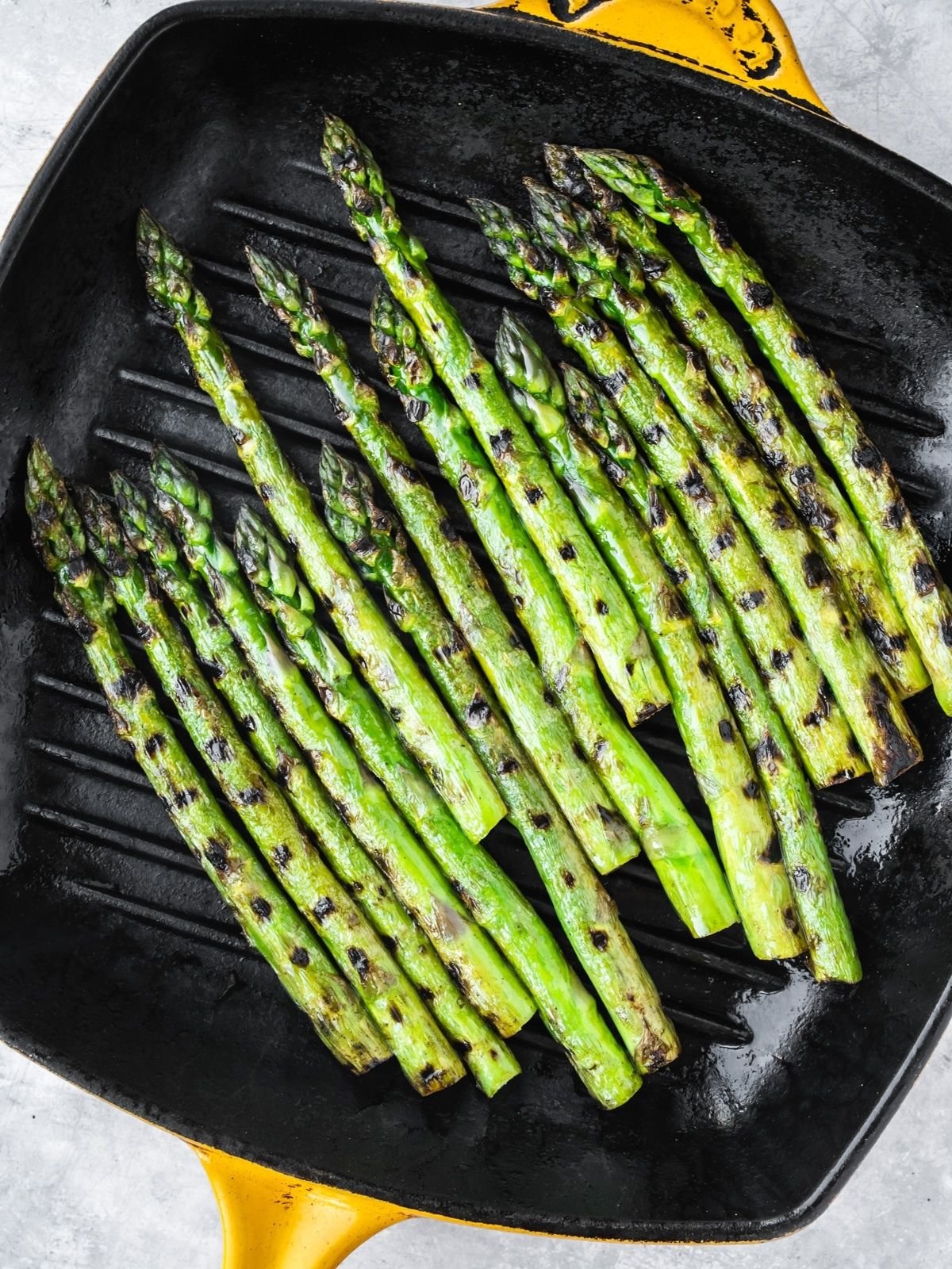 Grilling asparagus spears in a grill pan.