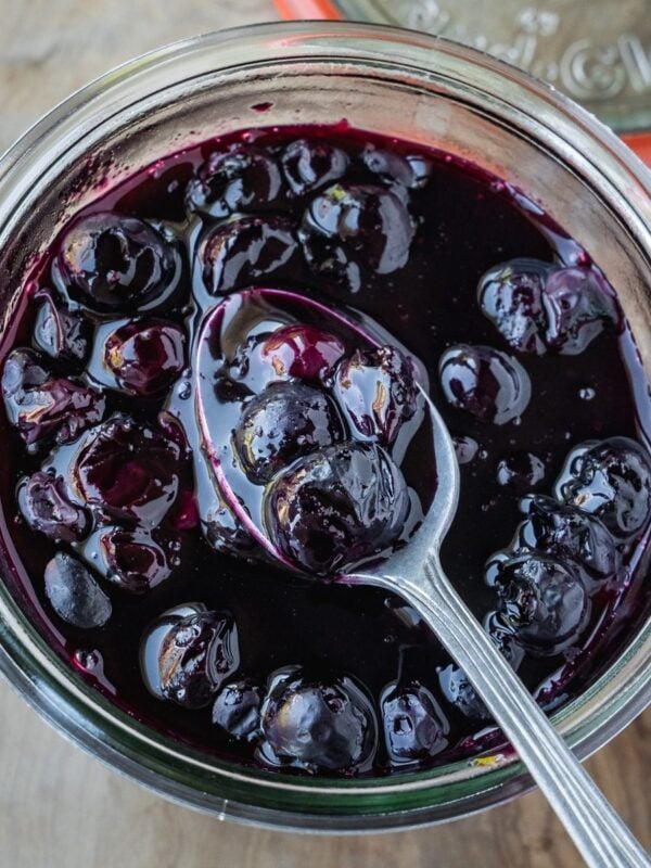 Blueberry Maple Compote in a jar with a spoon.