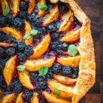 Blueberry Peach Galette garnished with mint on a wooden board.