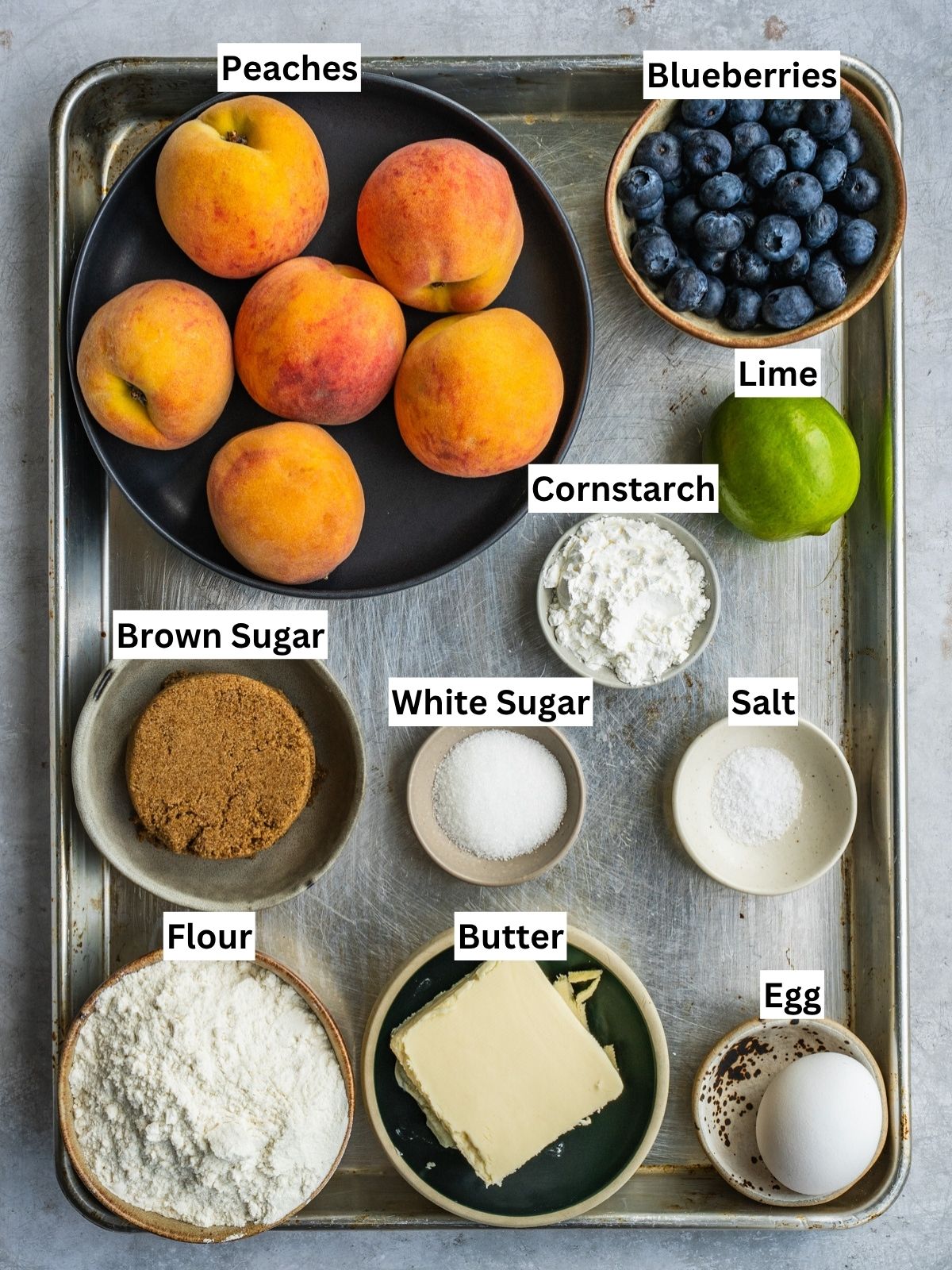 Blueberry Peach Galette recipe ingredients with individual labels on a metal tray.