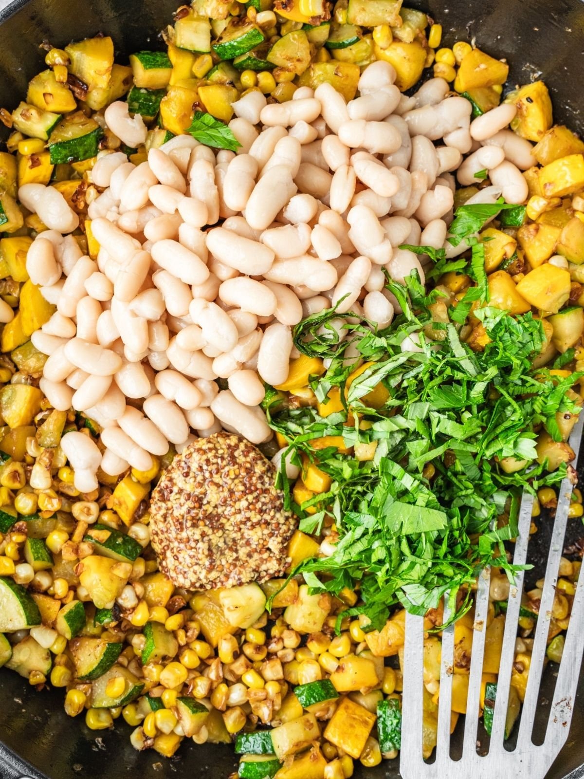 White beans, dijon and chopped basil getting added to the sauté pan.