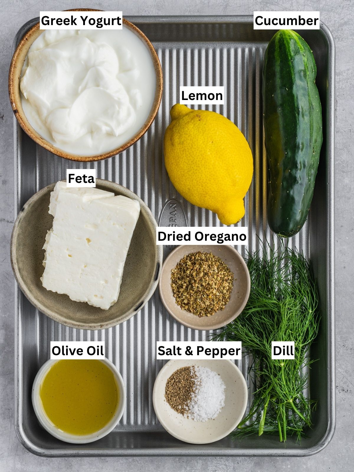 Feta yogurt dip recipe ingredients with individual labels on a metal tray.
