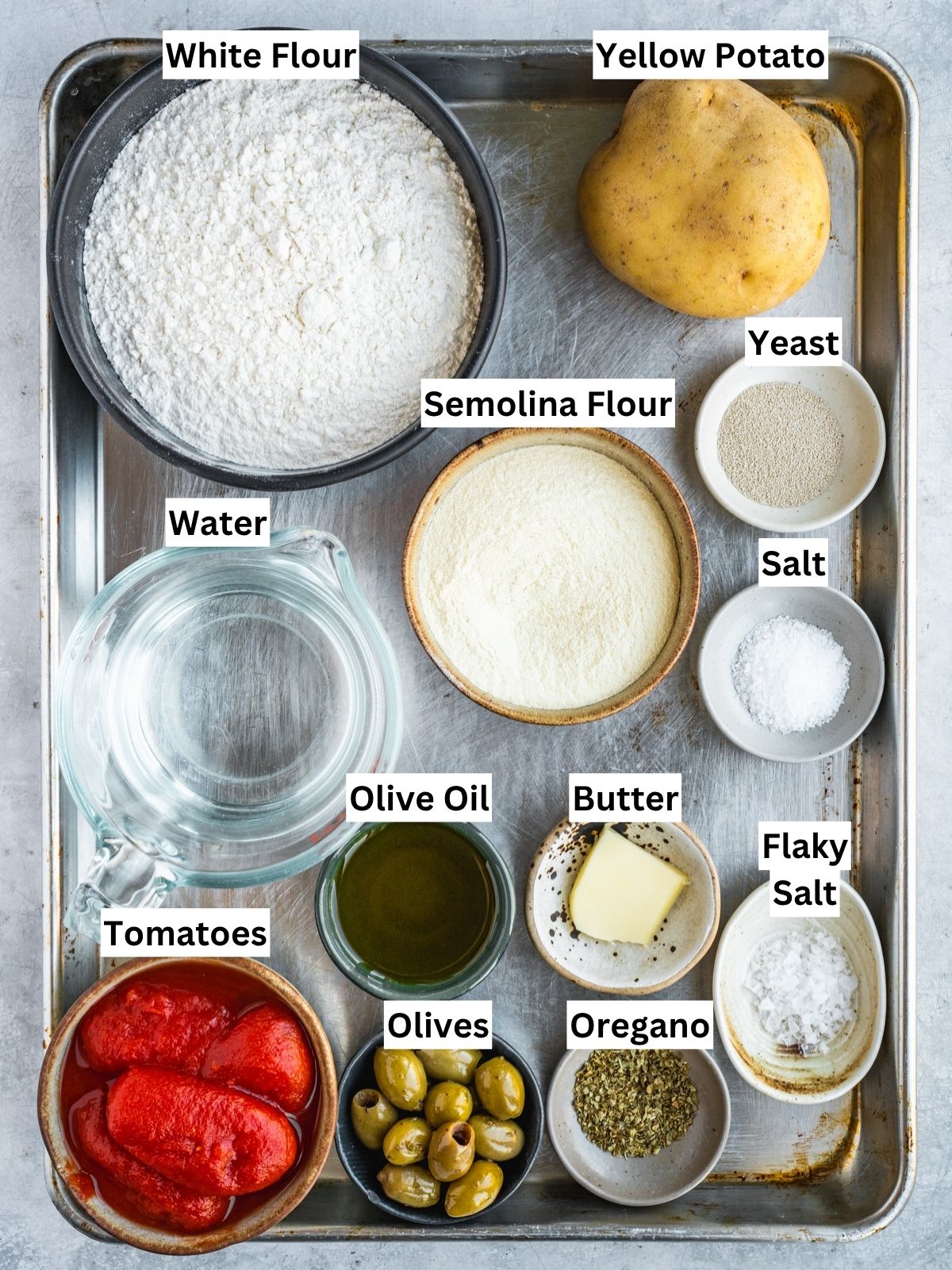 Focaccia Barese recipe ingredients with individual labels on a metal tray.