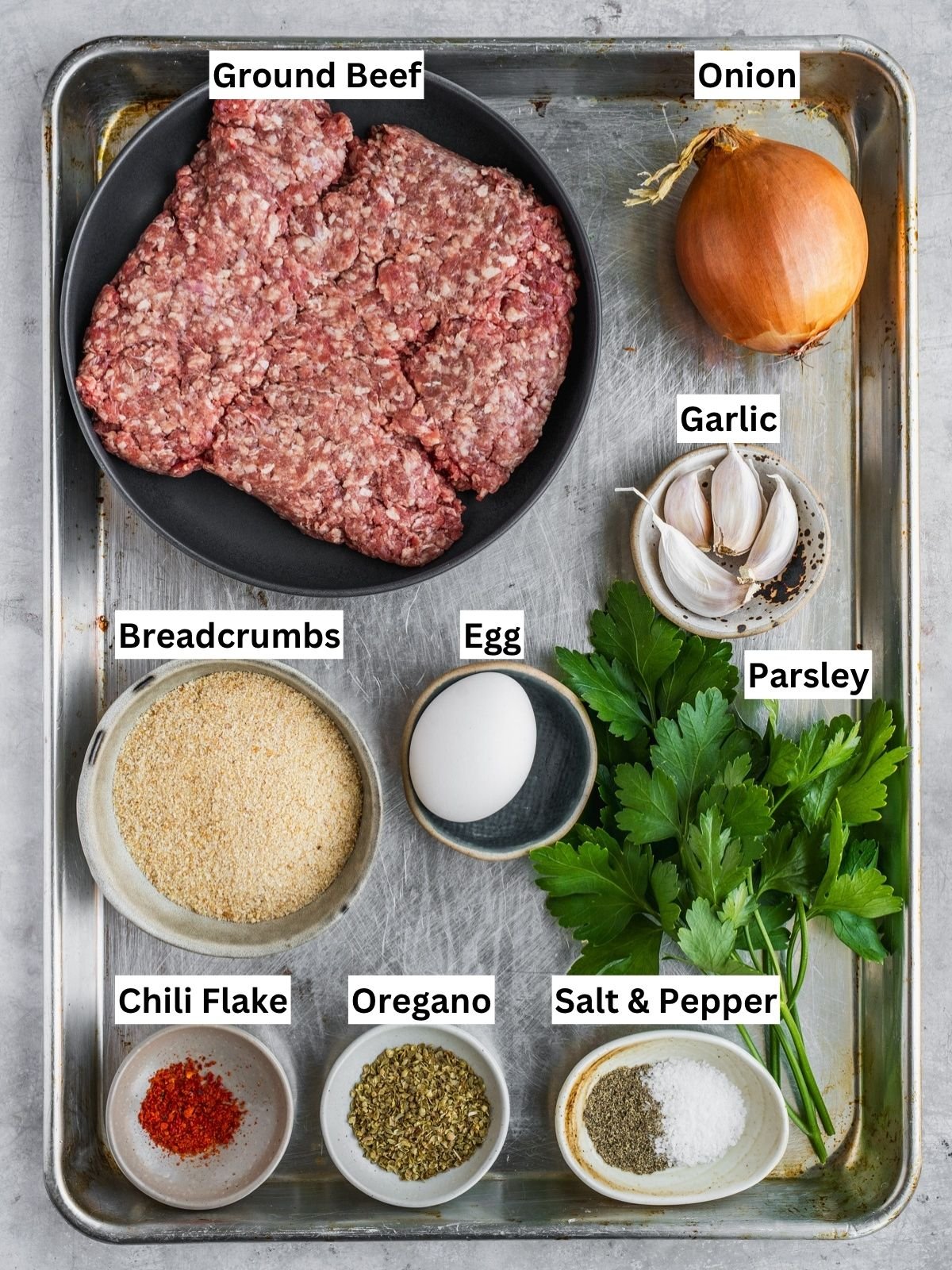Greek Meatballs (Keftedes) recipe ingredients with individual labels on a metal tray.
