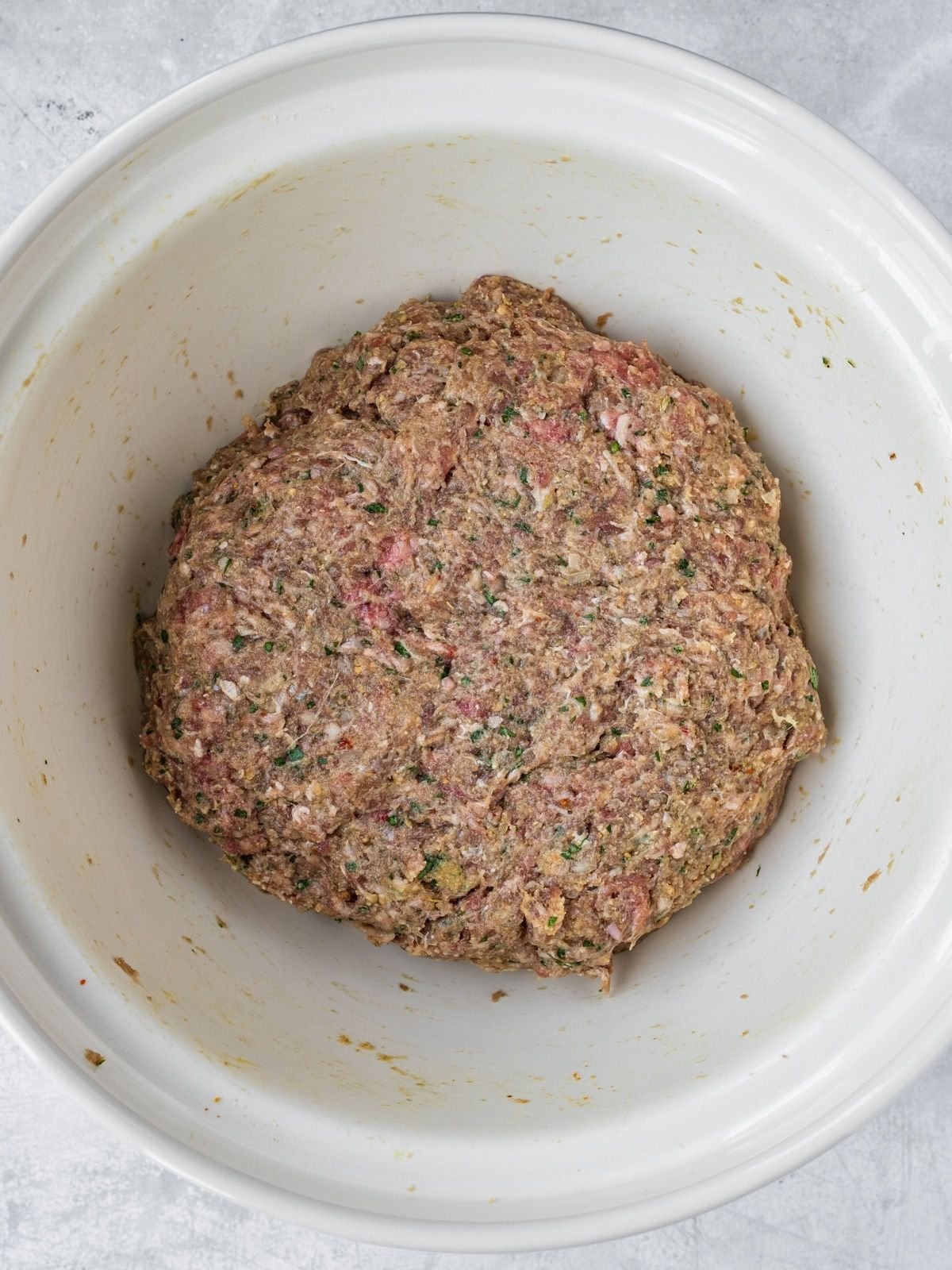 Large bowl showing the final mixed ground beef meatball mixture.