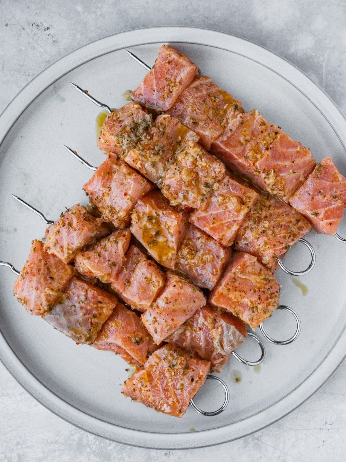 Marinated salmon cubes on metal skewers.