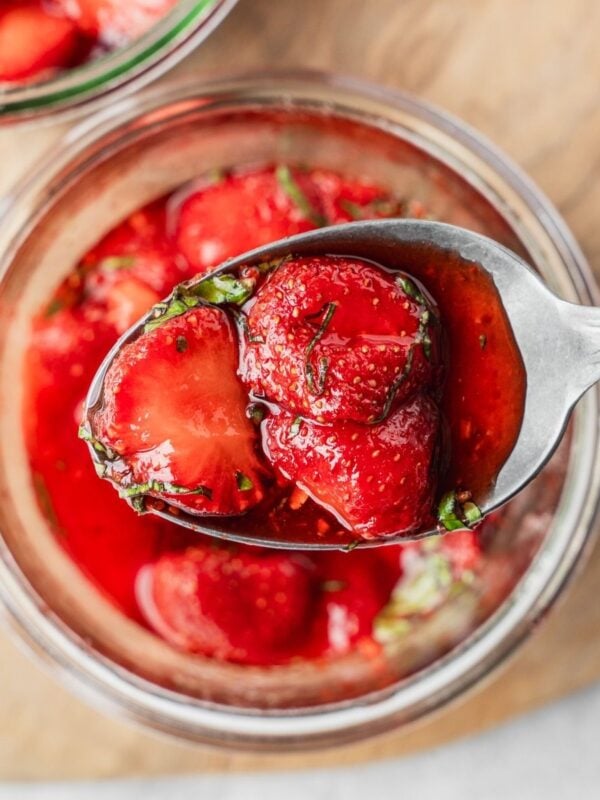 A spoonful of macerated strawberries with sliced basil.