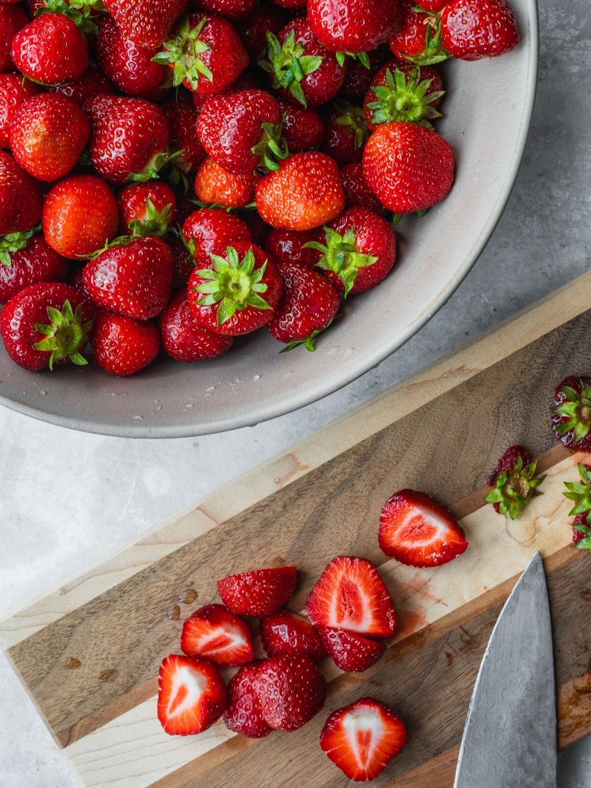 Cutting strawberries on a wooden board.