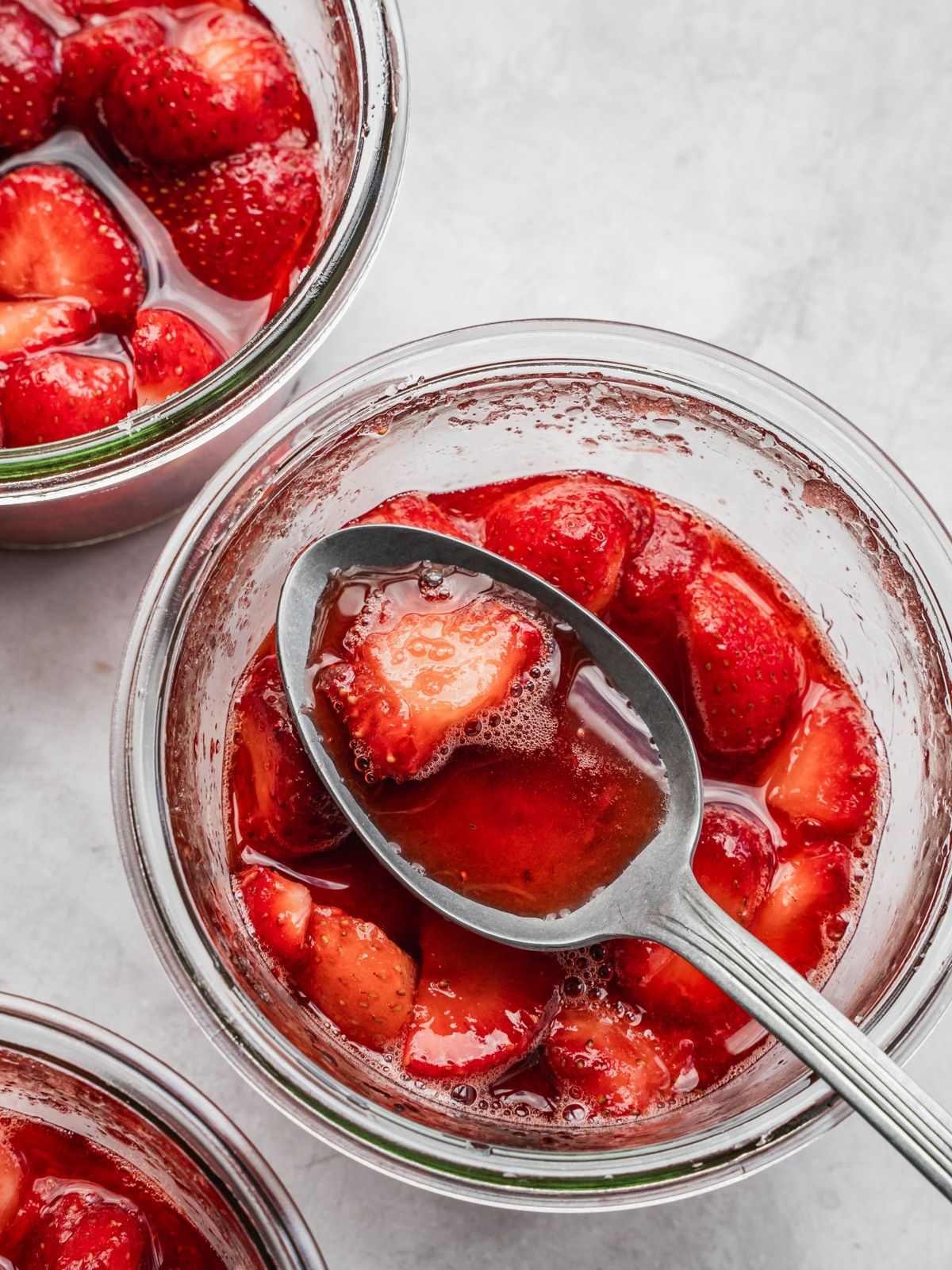 A spoonful of macerated strawberries in their own syrup.