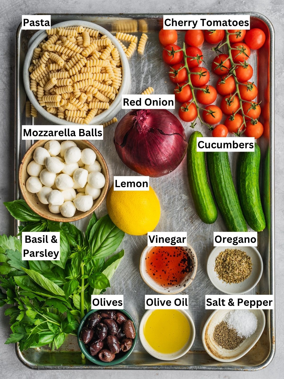 Mediterranean pasta salad recipe ingredients with individual labels in a tray.