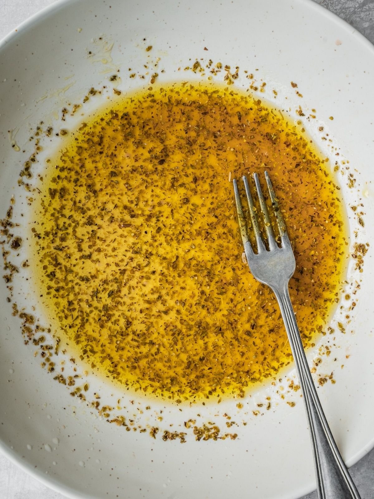 Recipe step showing the mixing of the salad dressing directly in the serving bowl.