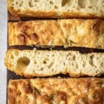 Same Day Focaccia sliced and laid out on a wooden cutting board.