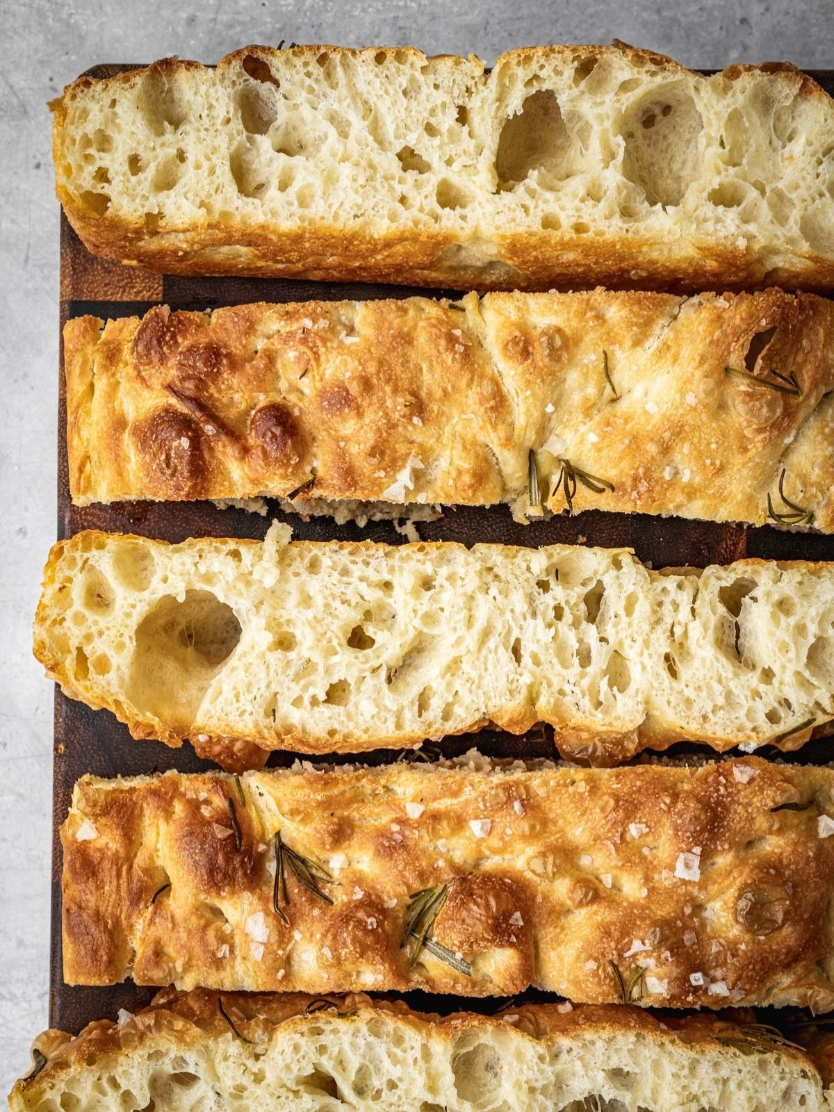 Same Day Focaccia sliced and laid out on a wooden cutting board.