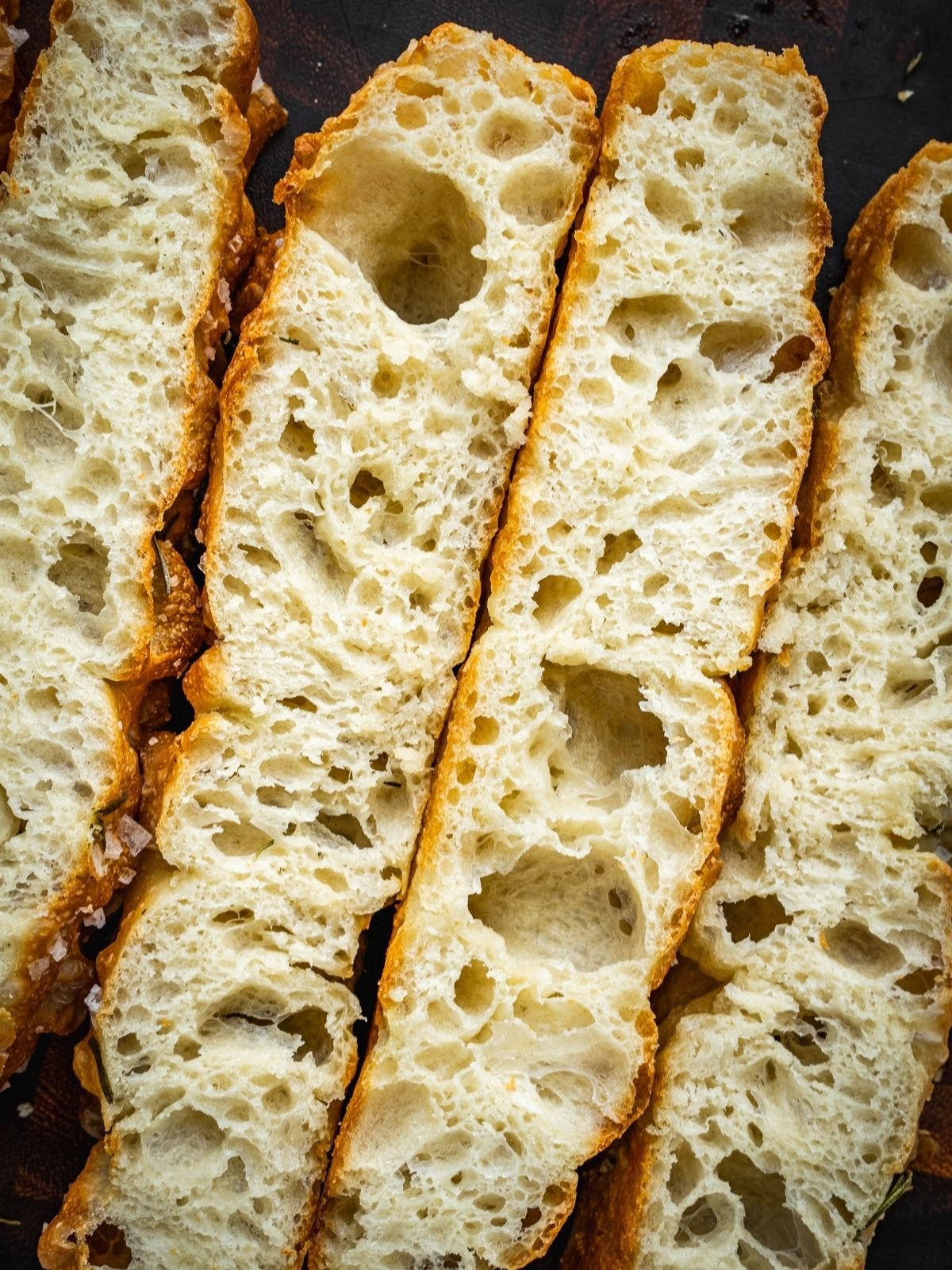 Same Day Focaccia sliced and laid out on a wooden cutting board.