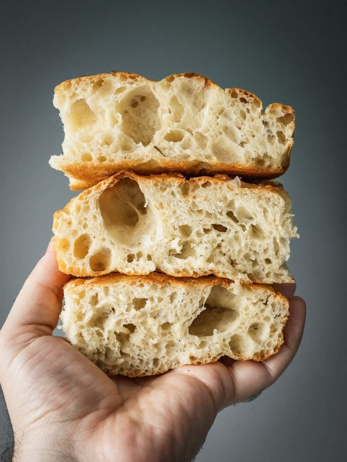 Sliced of focaccia stacked in a hand.
