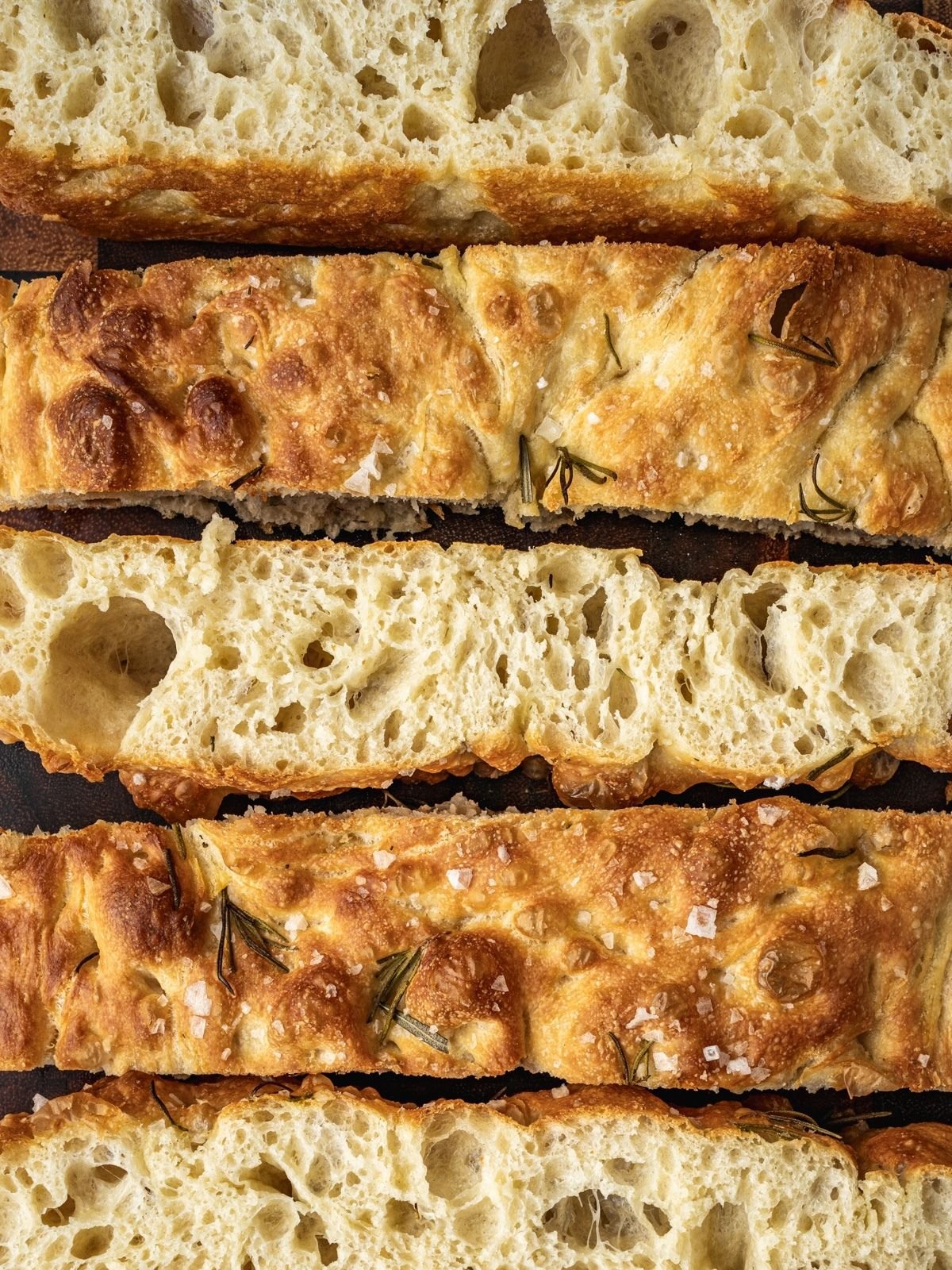 Same Day Focaccia sliced and laid out on a wooden cutting board.
