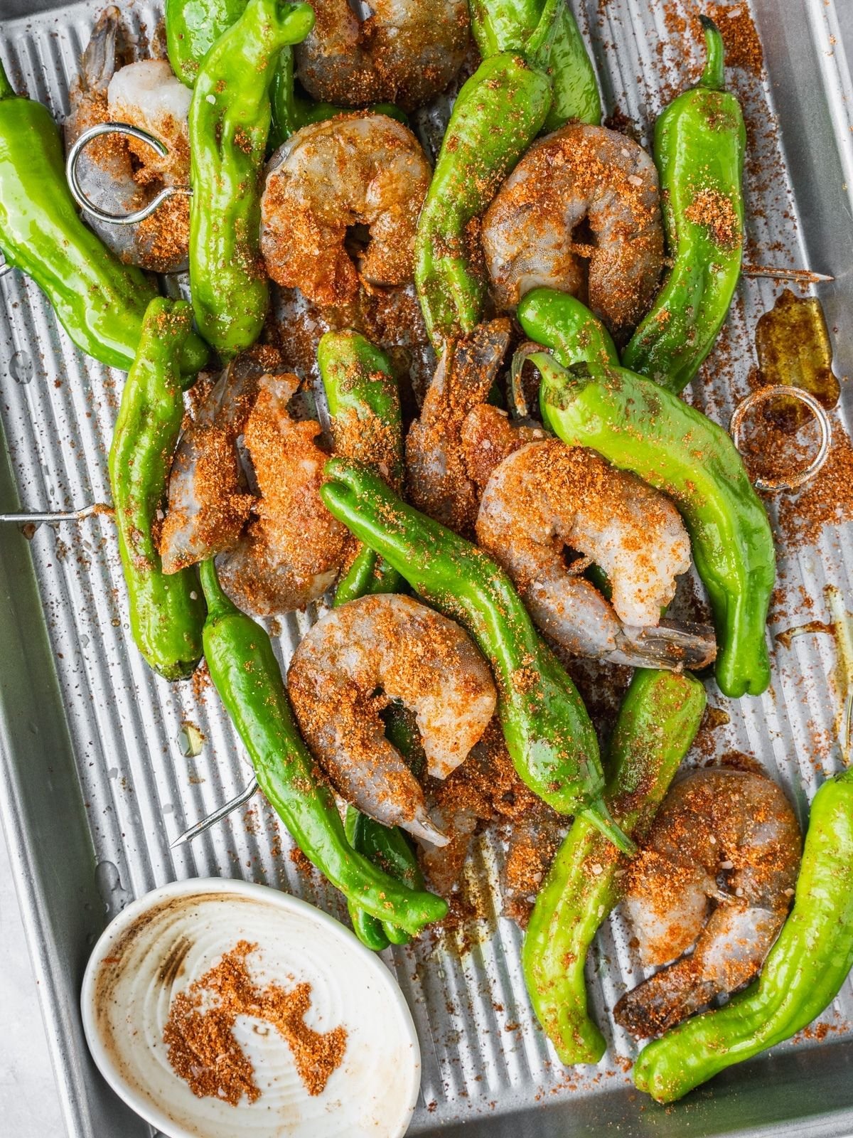 Seasoning the skewers with the dry rub.