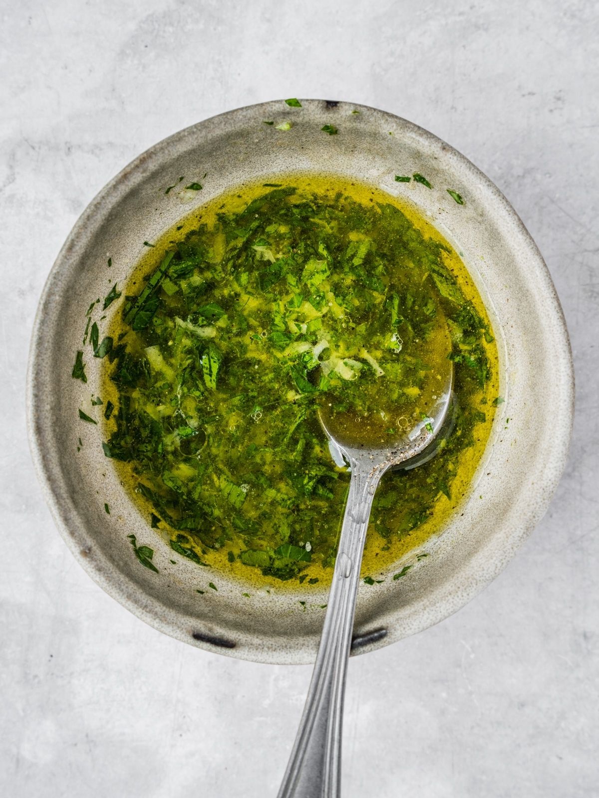 A small bowl with the lemon, olive oil, garlic and herb sauce.