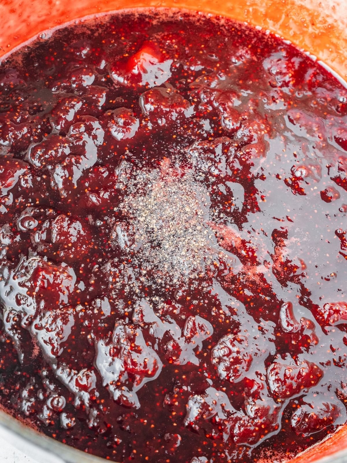 Adding the black pepper and balsamic vinegar to the cooked jam.