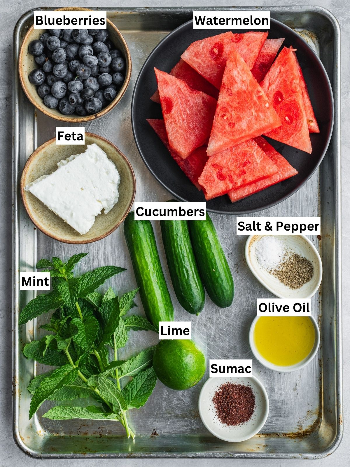 Watermelon blueberry feta salad recipe ingredients with individual labels on a tray.
