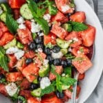 Watermelon blueberry feta salad with fresh mint and cucumber in a serving bowl.