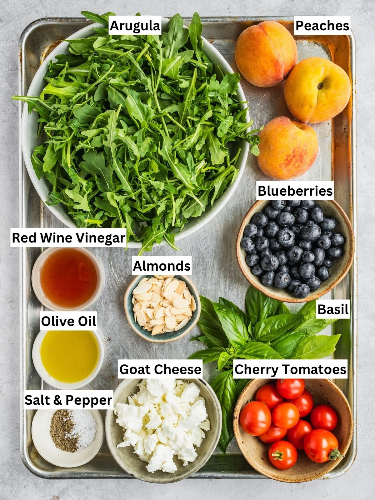 Grilled peach salad recipe ingredients with individual labels on a metal tray.