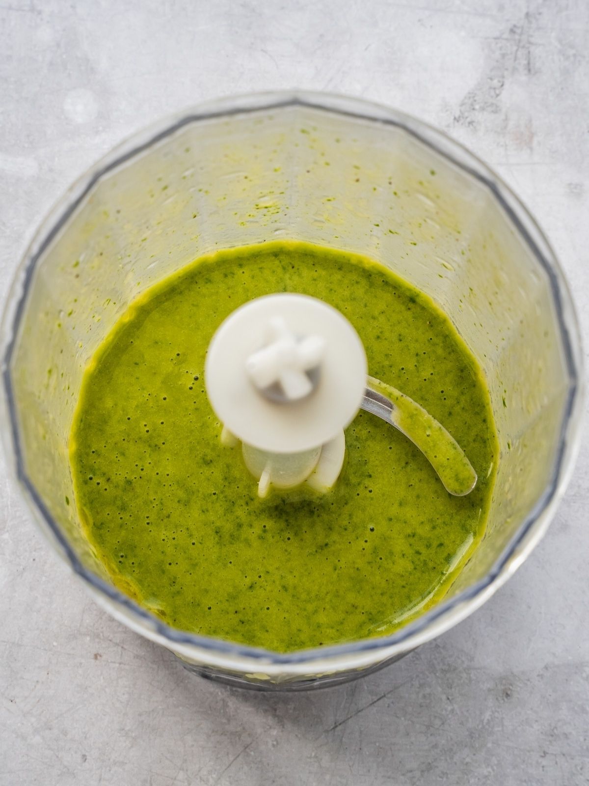 A small food processor with a blended salad dressing.