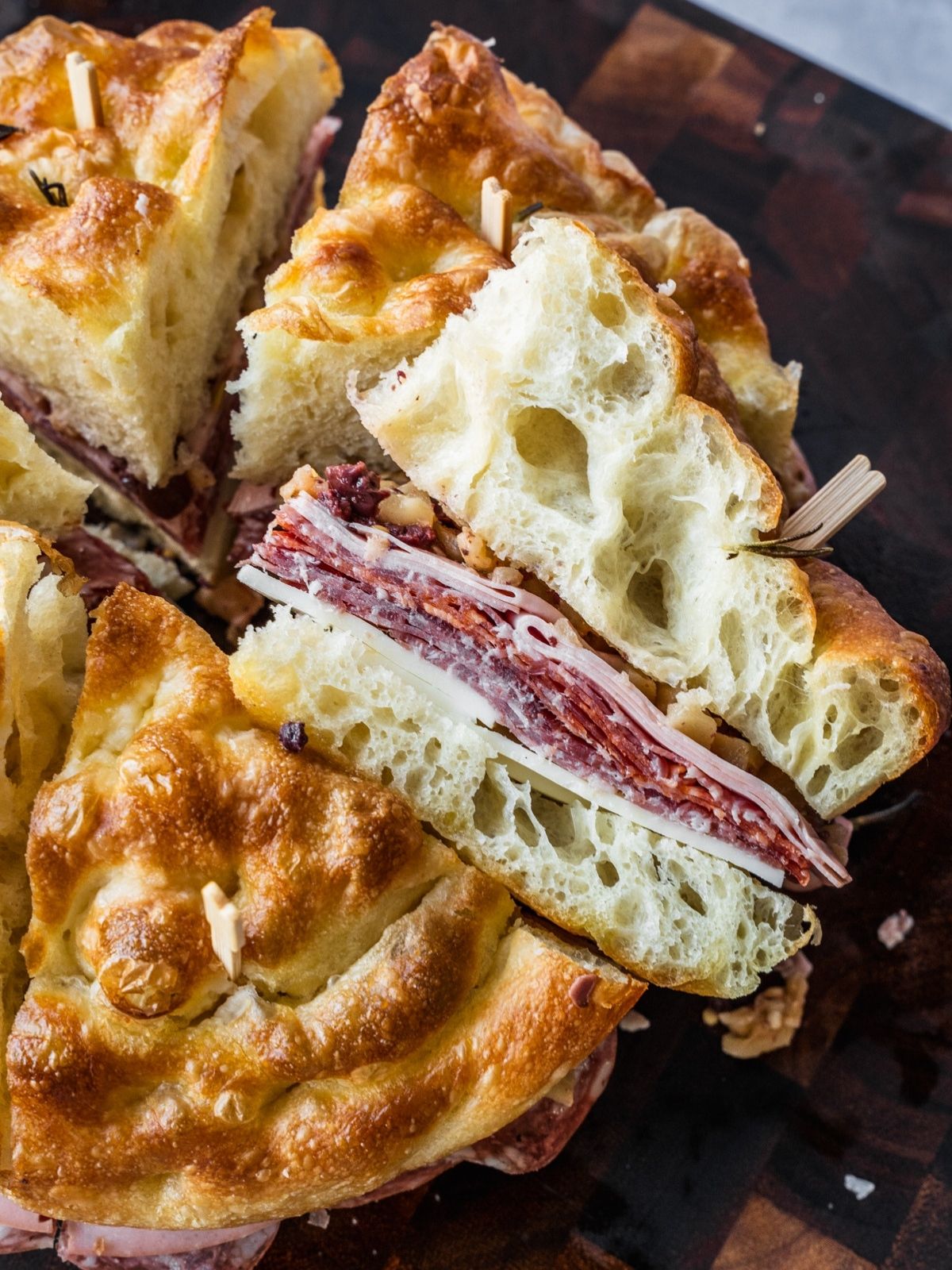Cross-section of a muffuletta slice showing the deli meat and cheese.