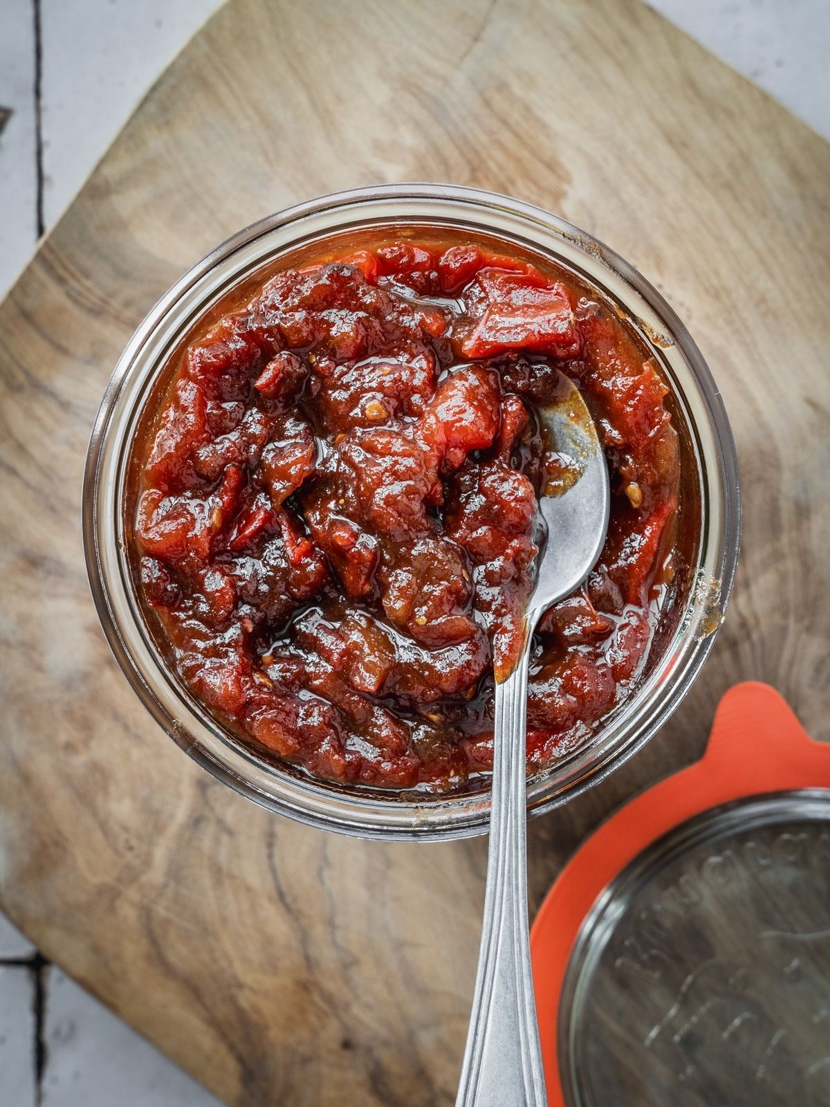 A mason jar filled to the top with tomato jam.