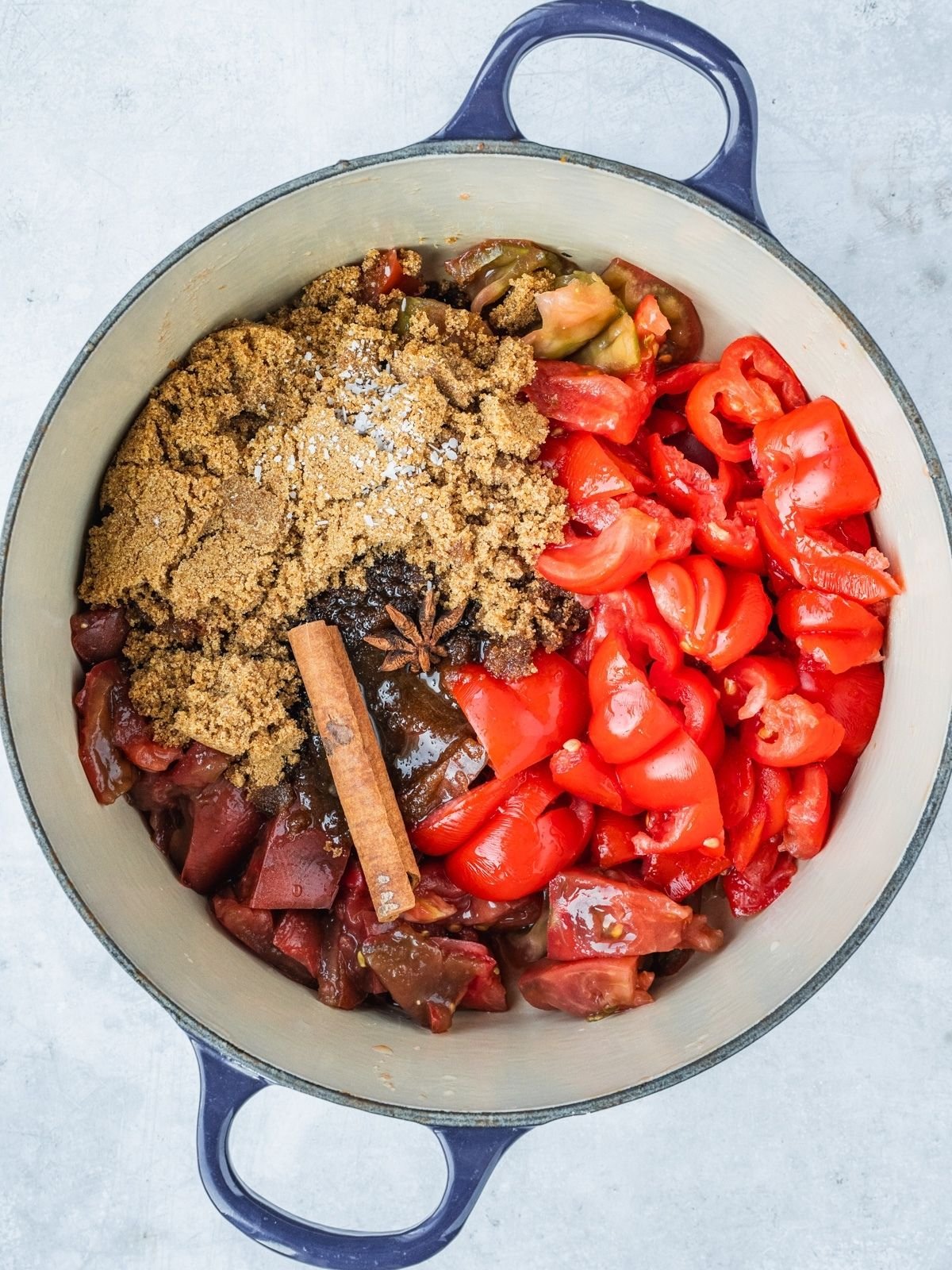 Pot with chunks of tomatoes, sugar, spices and vinegar.