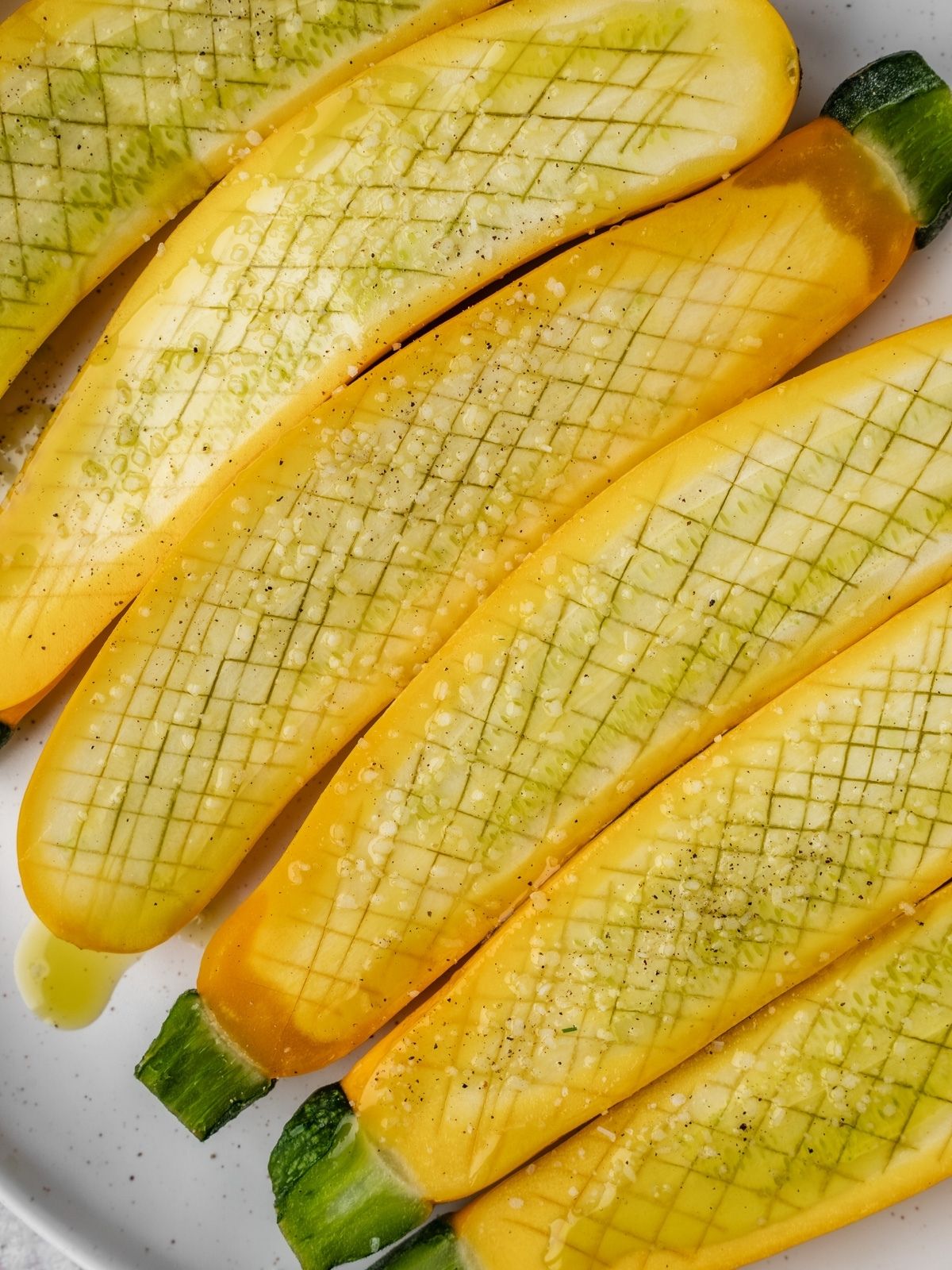 Zucchini halves seasoned with oil, salt and pepper.