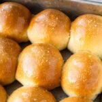 Buttery homemade dinner rolls in a baking tray.