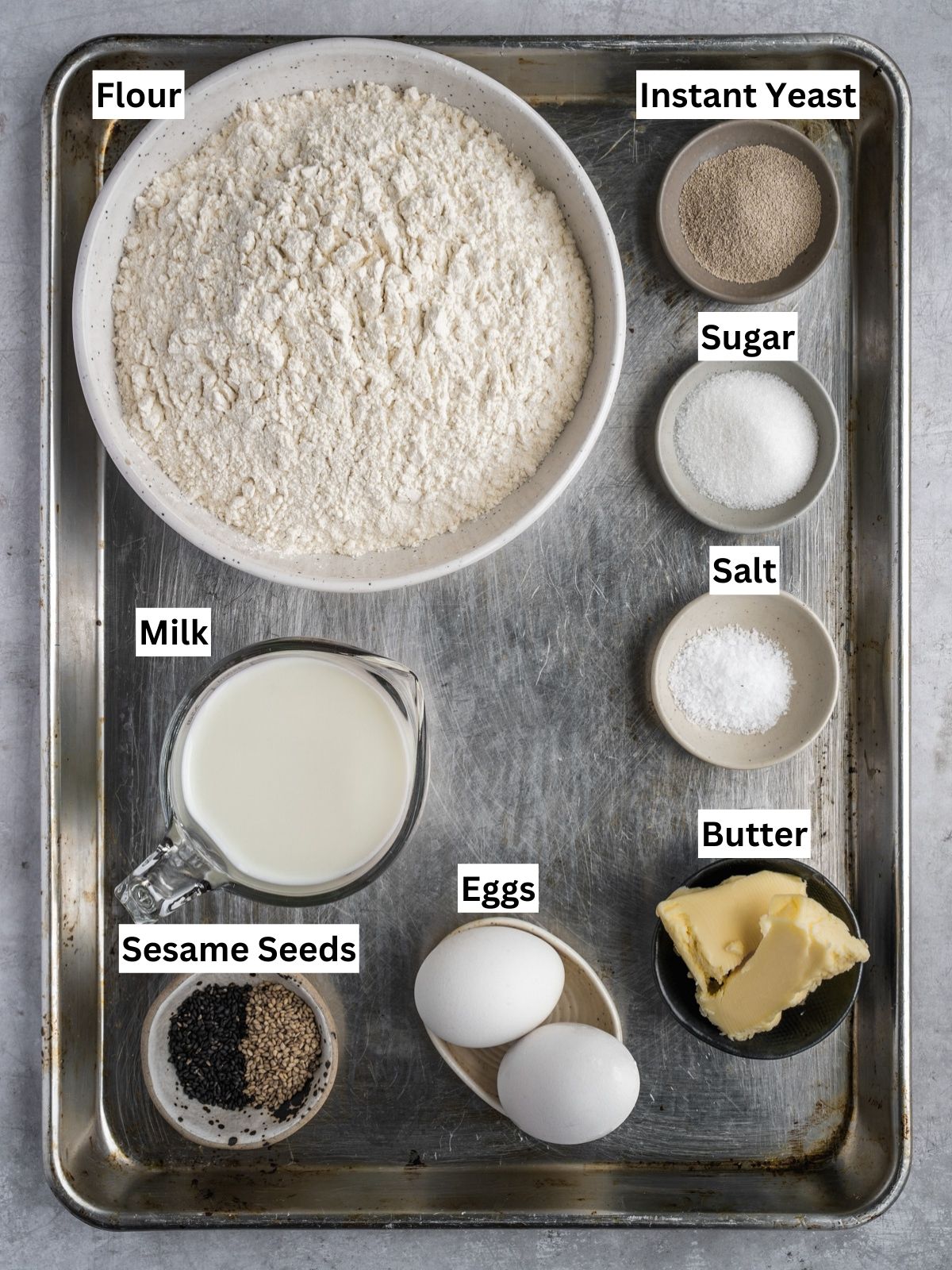 Homemade Hamburger Buns Recipe ingredients with individual labels on a metal tray.