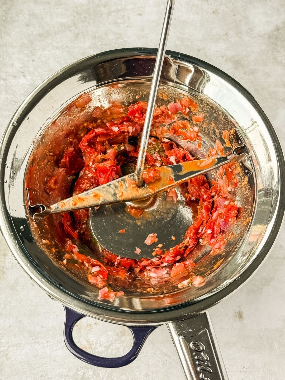 A food mill with the tomato sauce getting processed.