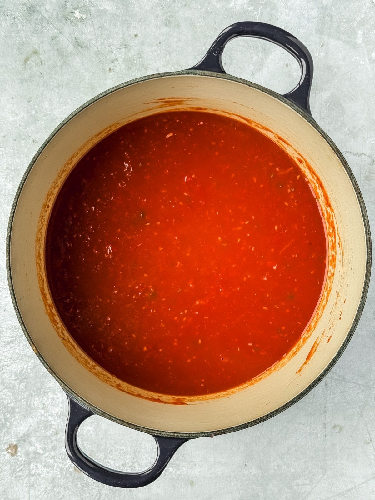 The final smooth midnight Roma tomato sauce in a pot.
