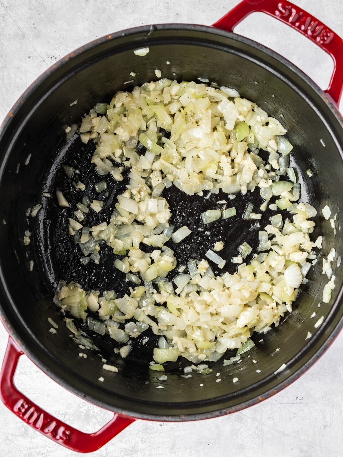 A large pot with onions and garlic sauteing.