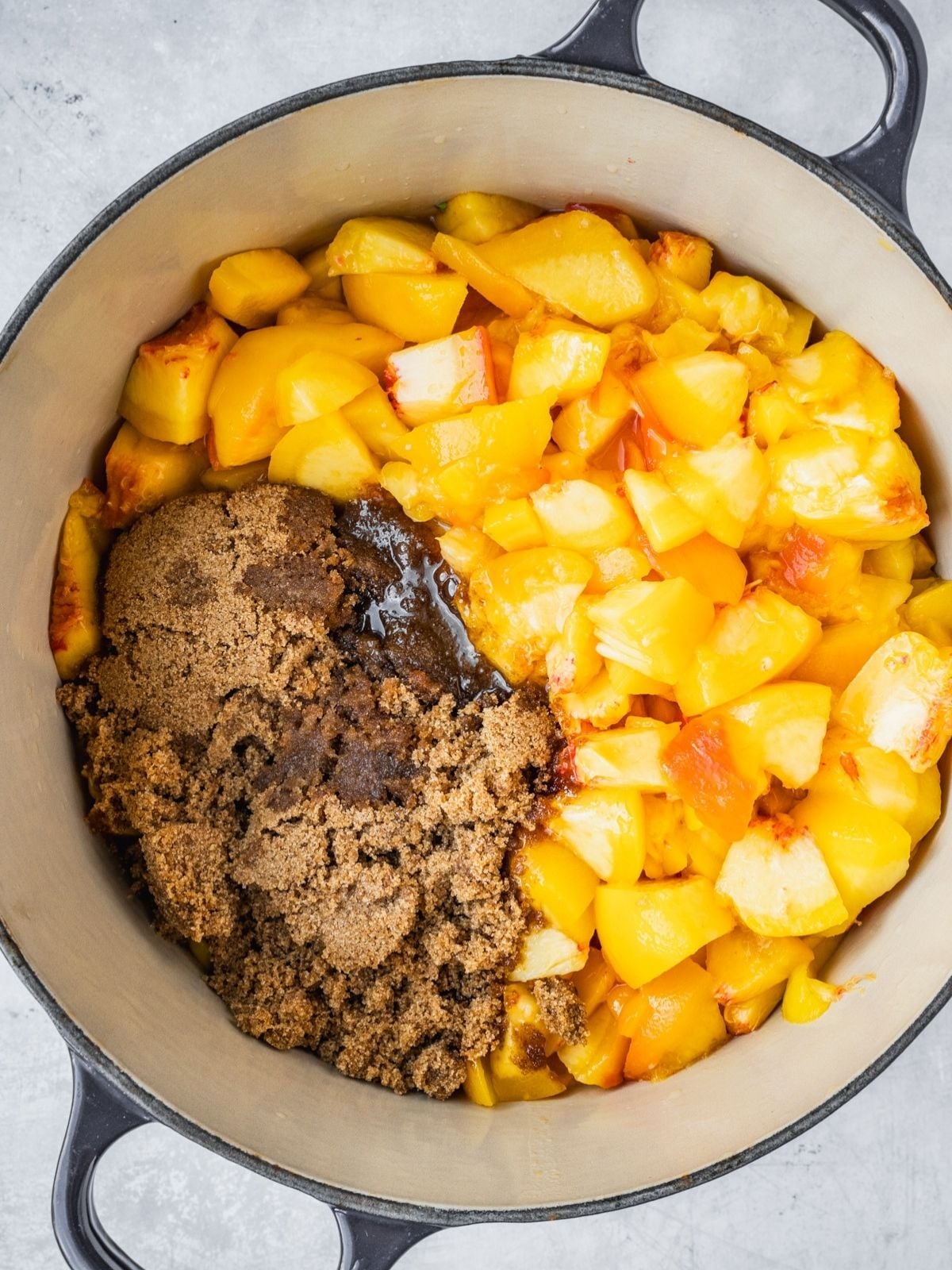 A pot with chopped, peeled peaches, brown sugar and lemon juice.