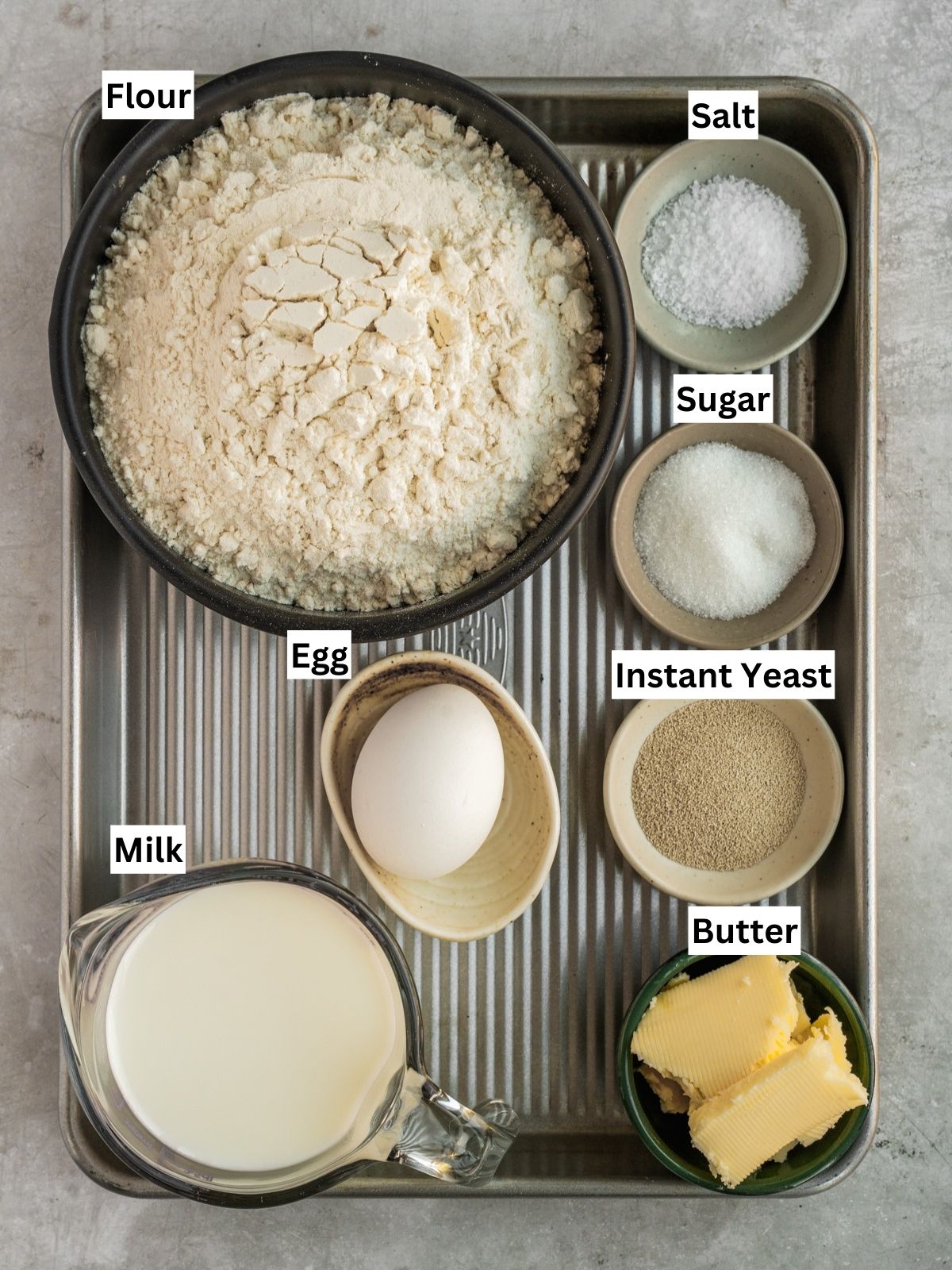 Double cheeked buns recipe ingredients with individual labels on a metal tray.