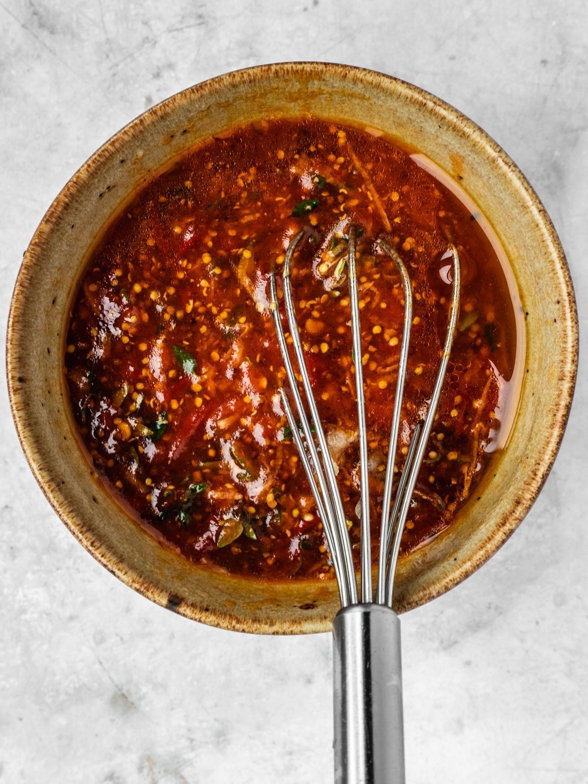 A bowl of harissa honey marinade with thyme, mustard and garlic.