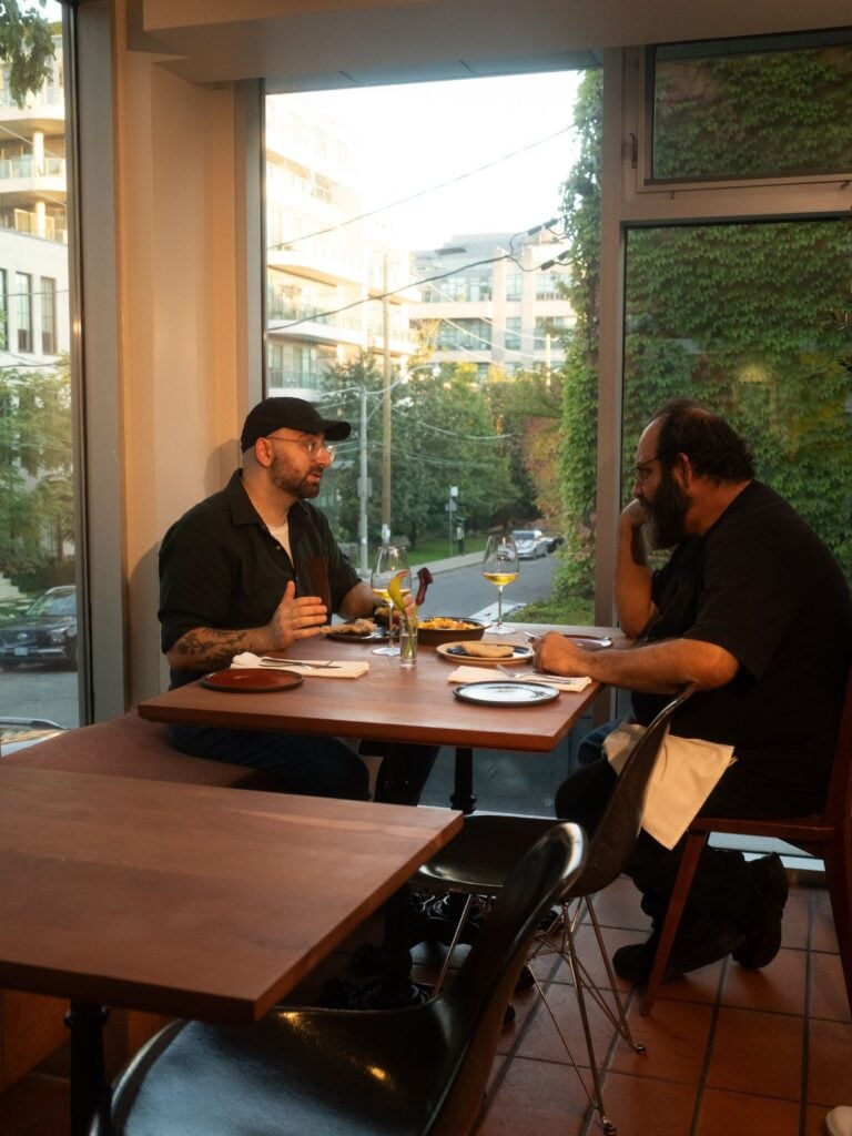 Luay and Chef Fadi Kattan at Louf discussing the recipe at a table in the restaurant.