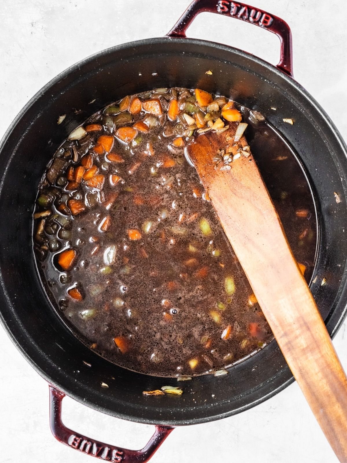 Pot with aromatics and braising liquid.