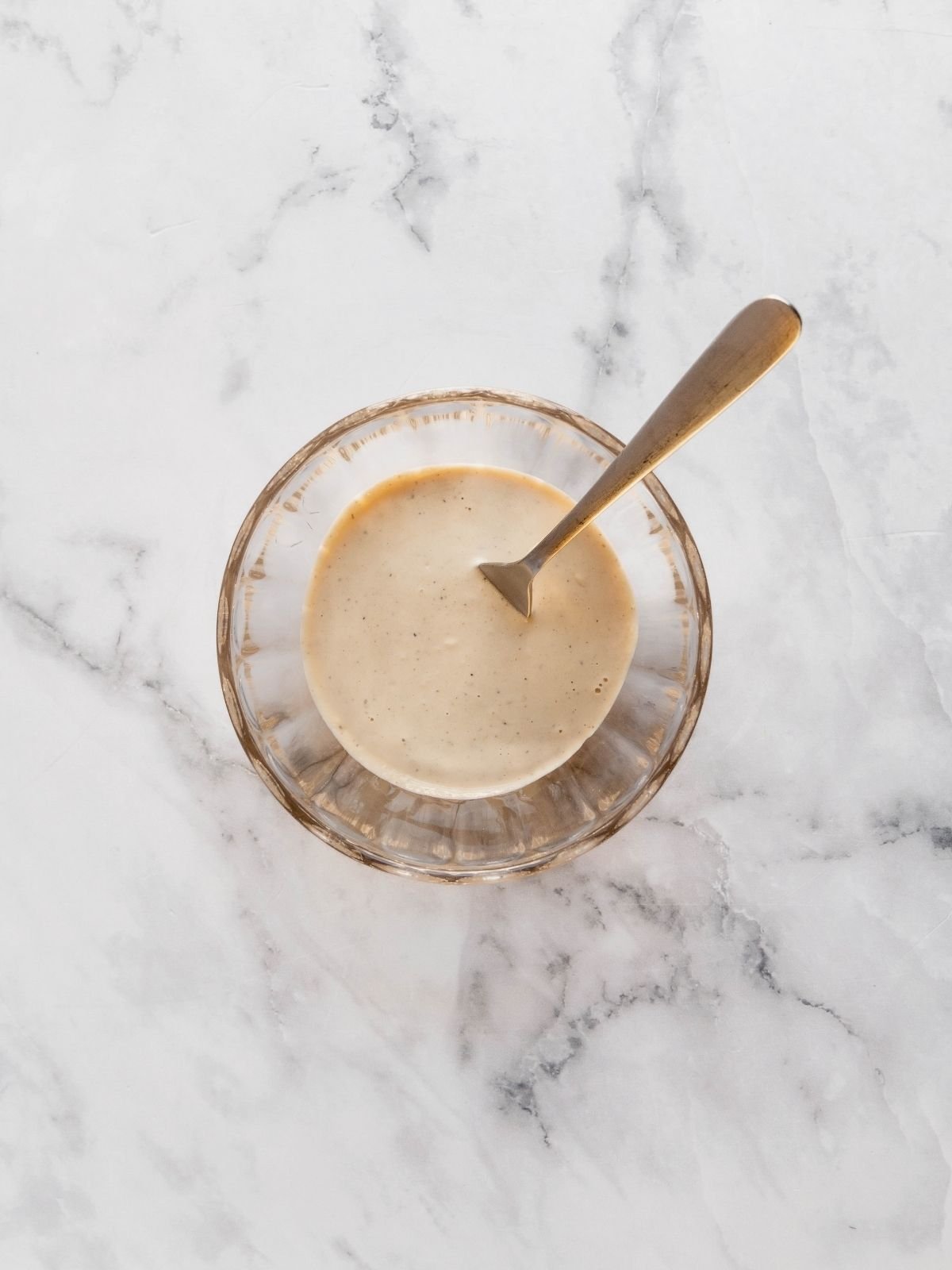 Tahini Caesar dressing in a small glass bowl.
