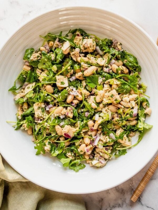 Bowl of tuna and white bean salad on a marble countertop.