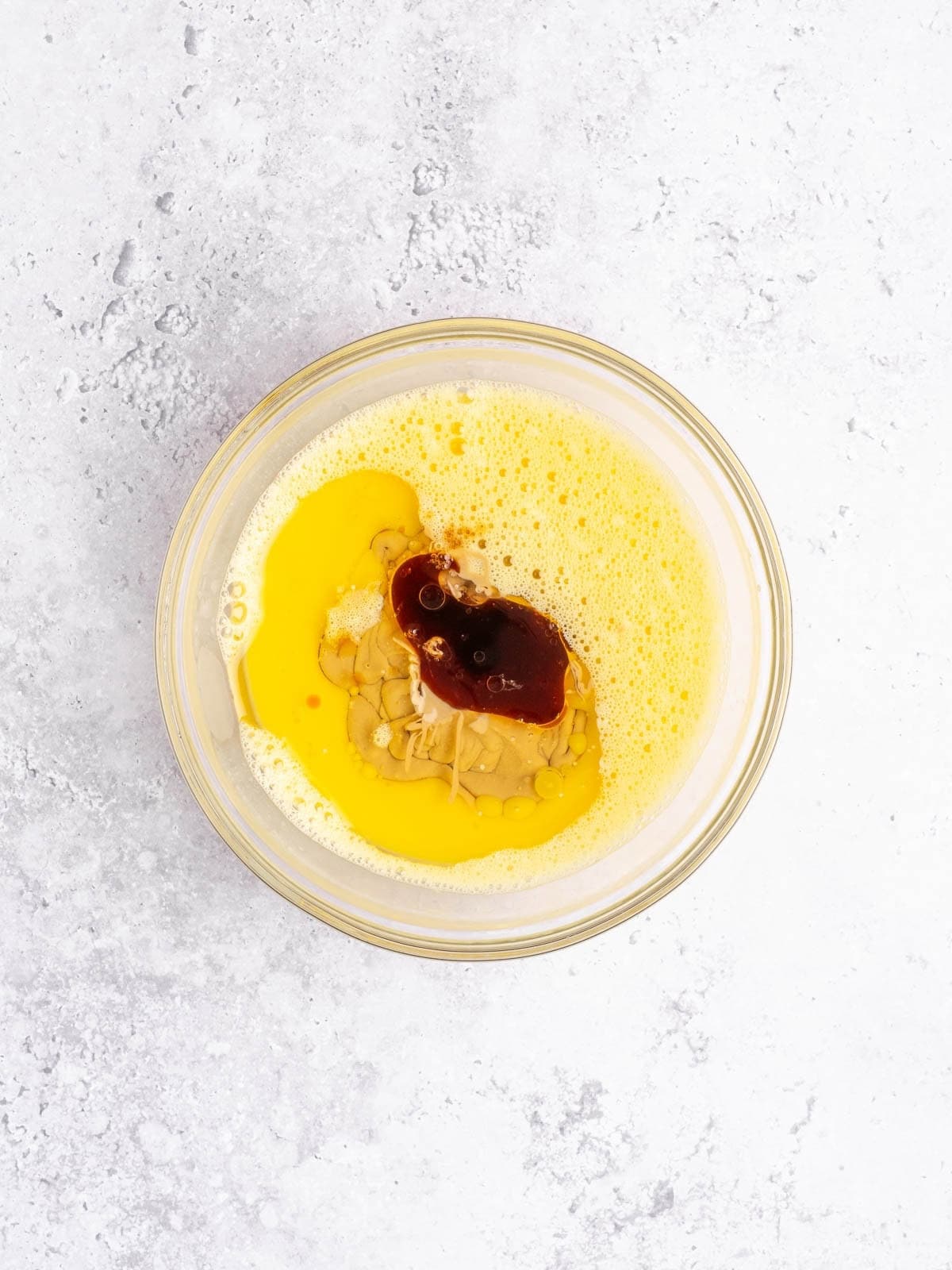 Recipe step showing the addition of the tahini and vanilla to the eggs.