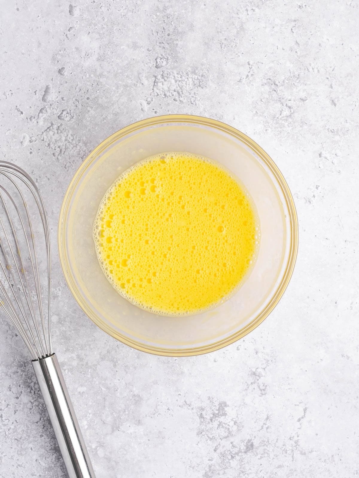 Small bowl with whisked up eggs.