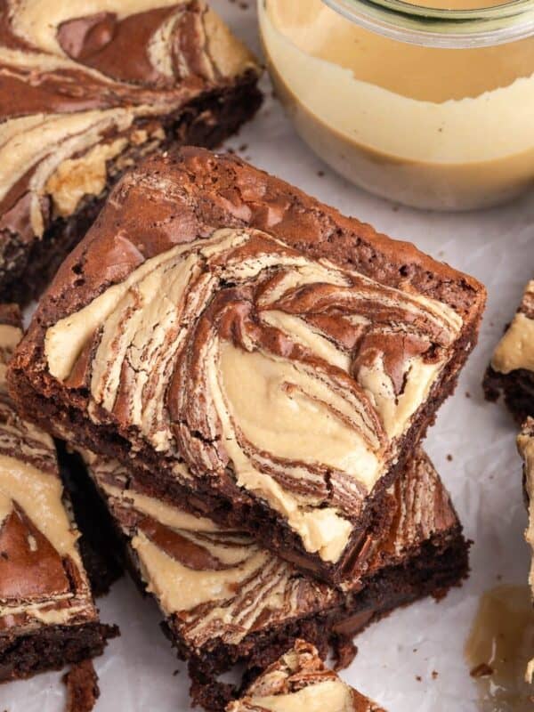 A stack of tahini brownies on parchment paper.