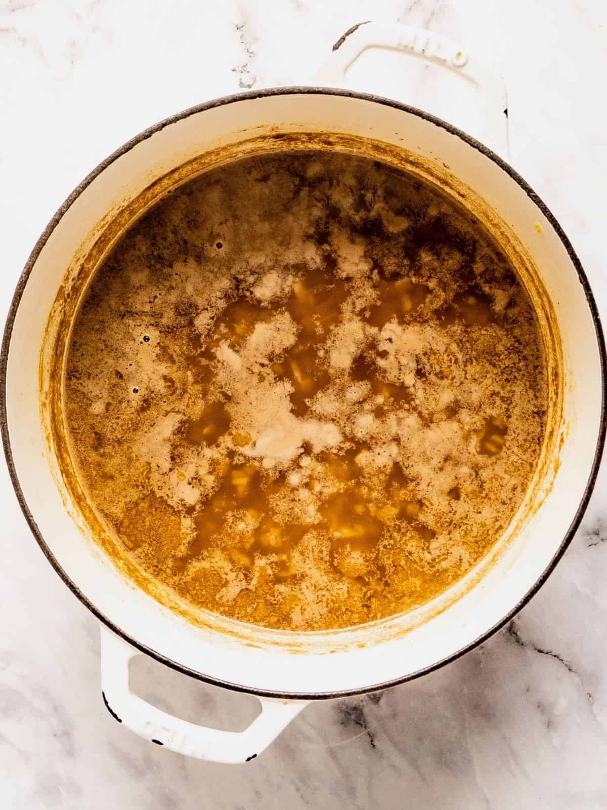 Recipe step showing the addition of the stock and lentils to the aromatic base.