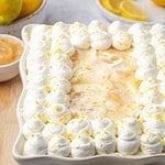 Limoncello tiramisu in a serving platter decorated with whipped cream and lemon zest.
