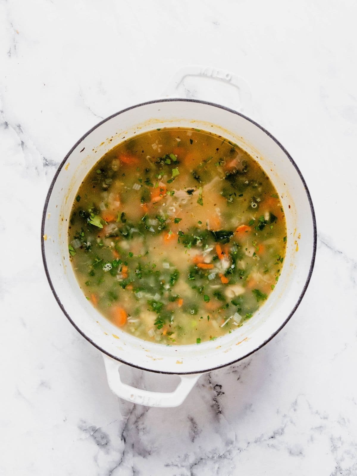 Soup pot with chopped kale added to the soup.