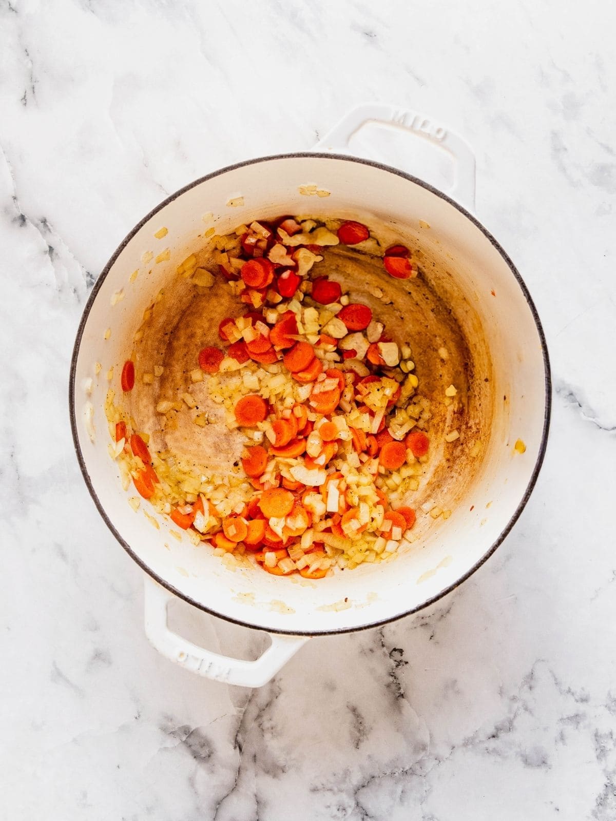 Soup pot with sautéed onion, carrot and garlic.